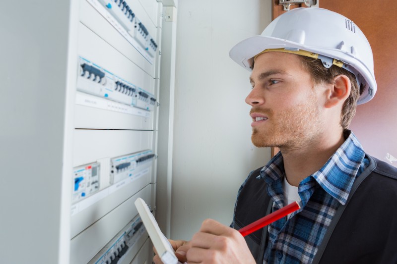 young electrician working on electric panel